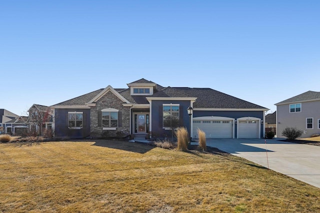 view of front of house with a garage, a front yard, concrete driveway, and stone siding