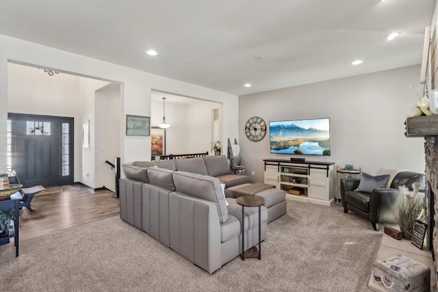 living room featuring light carpet, light wood finished floors, and recessed lighting