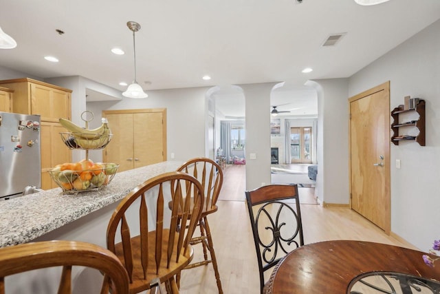 kitchen with light wood finished floors, recessed lighting, visible vents, freestanding refrigerator, and light brown cabinets