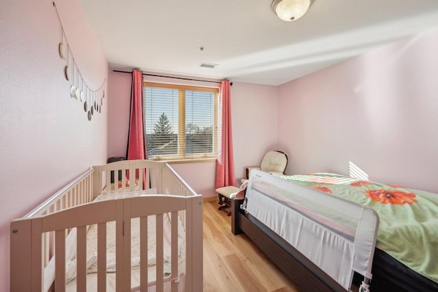 bedroom featuring visible vents and light wood finished floors