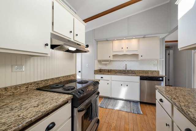 kitchen featuring white cabinets, appliances with stainless steel finishes, vaulted ceiling, under cabinet range hood, and a sink