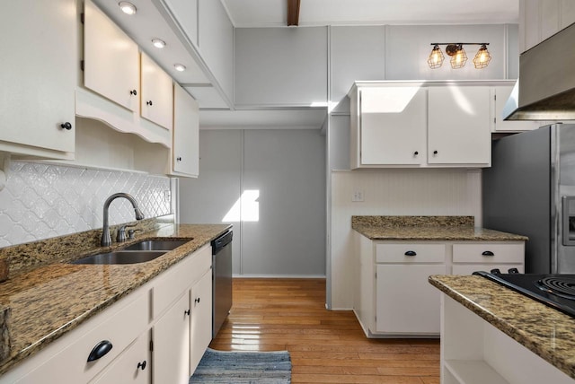 kitchen featuring stainless steel appliances, tasteful backsplash, light wood-style floors, white cabinets, and a sink