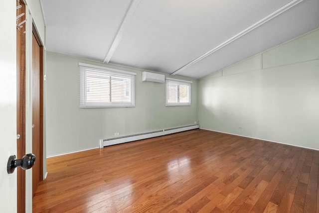 empty room featuring a baseboard heating unit, an AC wall unit, vaulted ceiling, and hardwood / wood-style floors