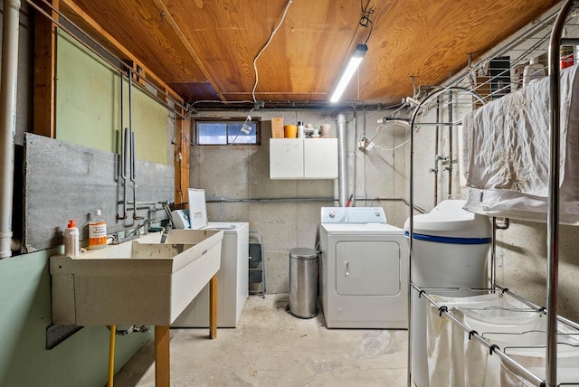 clothes washing area featuring a sink, laundry area, and washer and dryer