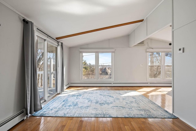 unfurnished living room featuring a baseboard radiator, wood-type flooring, and a healthy amount of sunlight