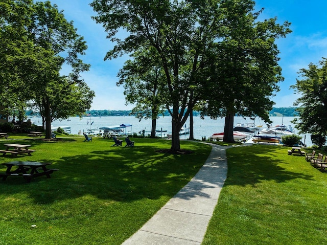 view of property's community with a water view and a yard