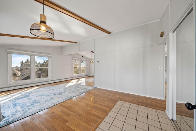 unfurnished living room featuring light wood-type flooring, vaulted ceiling with beams, and baseboard heating