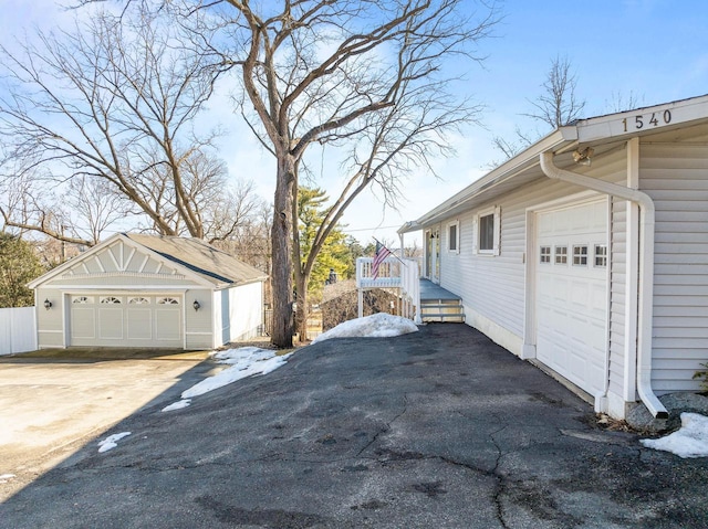 view of property exterior featuring a detached garage and an outdoor structure