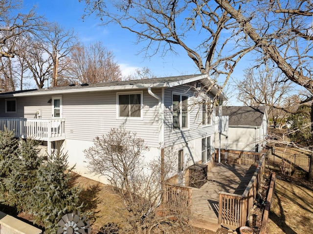 view of home's exterior featuring fence and a deck