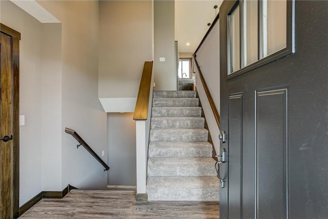 staircase featuring baseboards and wood finished floors