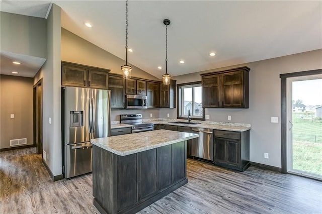 kitchen with light countertops, visible vents, appliances with stainless steel finishes, a sink, and dark brown cabinets