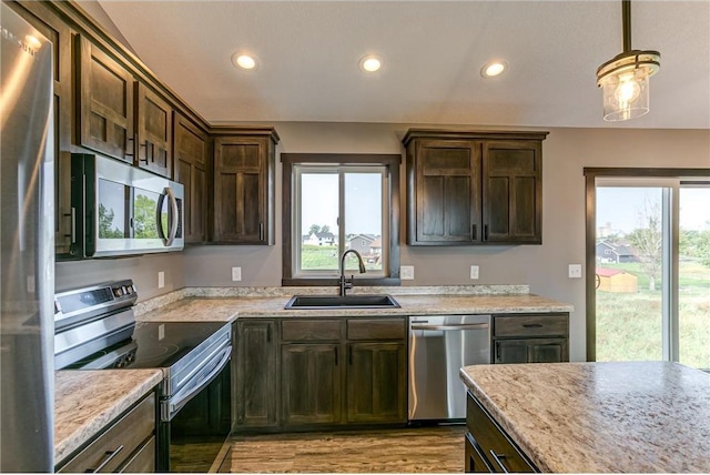 kitchen with appliances with stainless steel finishes, plenty of natural light, and a sink