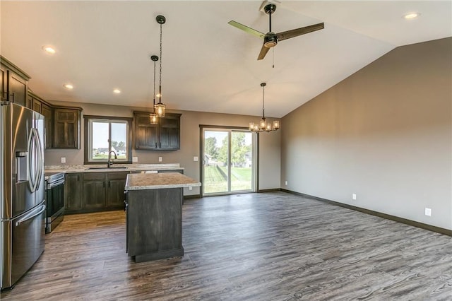 kitchen featuring a sink, plenty of natural light, stainless steel fridge, and a center island