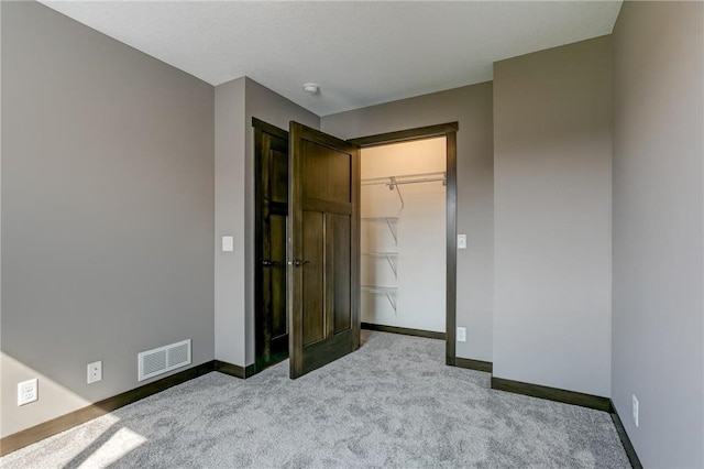 unfurnished bedroom with carpet, a closet, visible vents, and baseboards