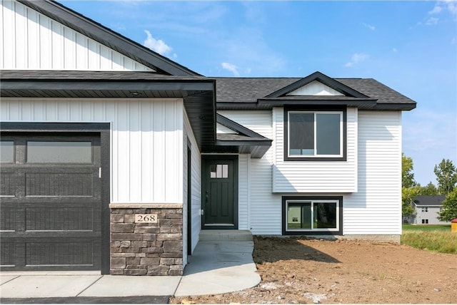 view of front of home with a shingled roof and an attached garage