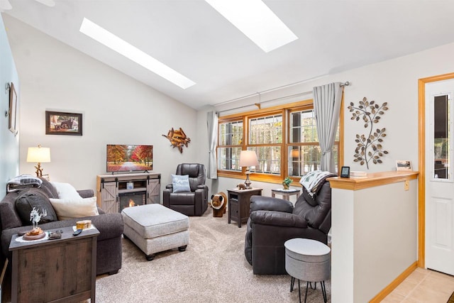 living area featuring light carpet, vaulted ceiling with skylight, light tile patterned floors, and a warm lit fireplace