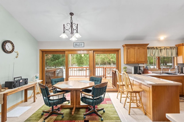 dining area with vaulted ceiling, a notable chandelier, and light tile patterned flooring