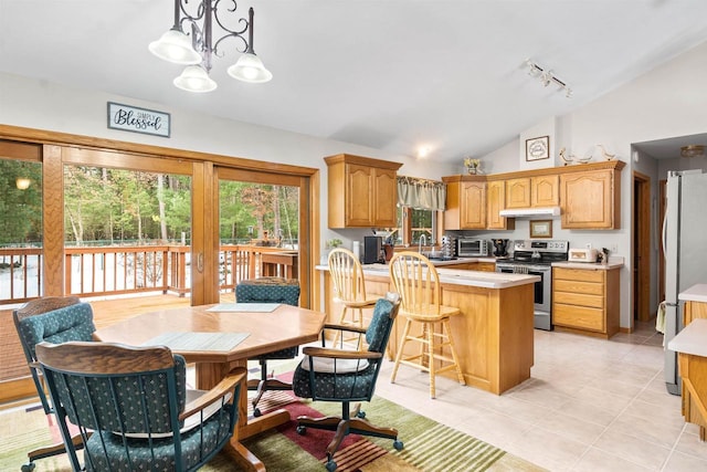 kitchen featuring lofted ceiling, a kitchen breakfast bar, light countertops, stainless steel range with electric cooktop, and a notable chandelier