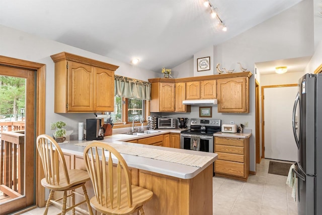 kitchen with lofted ceiling, light countertops, appliances with stainless steel finishes, a sink, and a peninsula