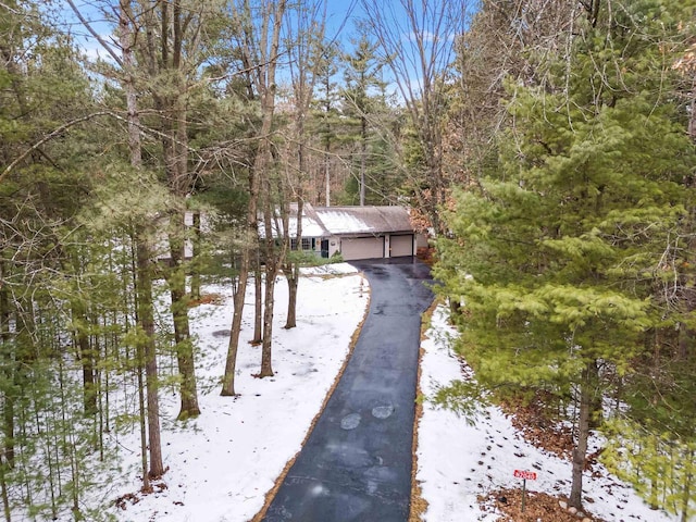 exterior space with a garage and a wooded view