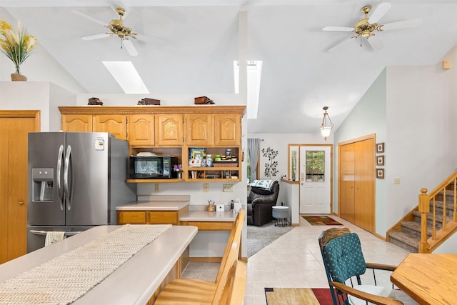 kitchen with ceiling fan, black microwave, light countertops, and stainless steel fridge with ice dispenser