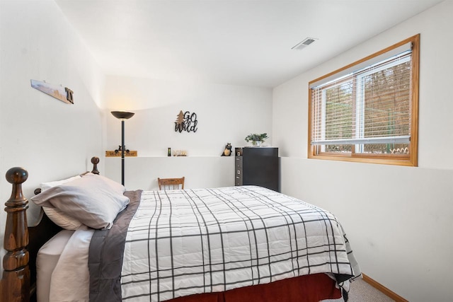 carpeted bedroom featuring baseboards and visible vents