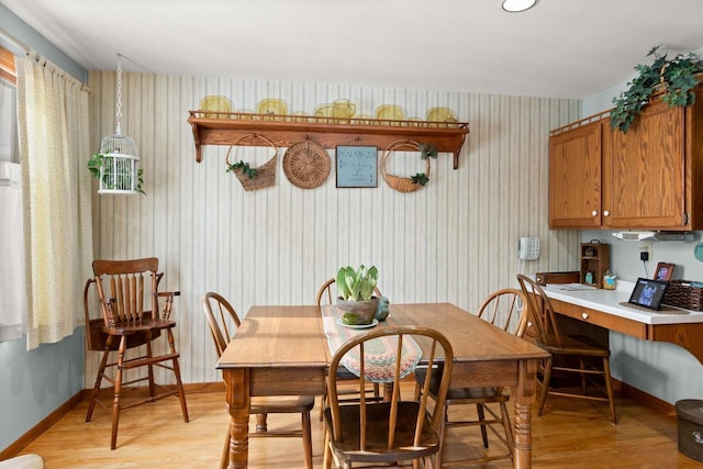 dining area featuring light wood-type flooring and baseboards