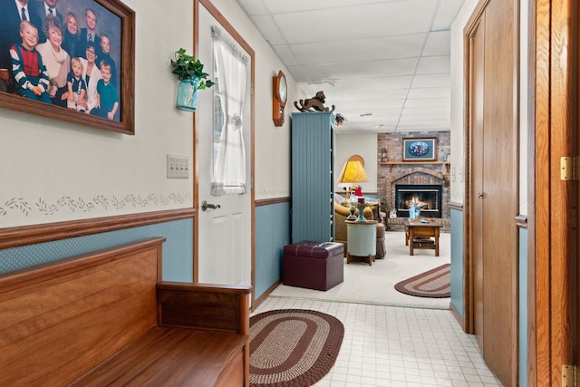 hall featuring a wainscoted wall and a drop ceiling