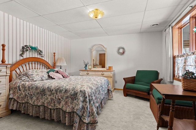 bedroom with baseboards, light carpet, visible vents, and a drop ceiling