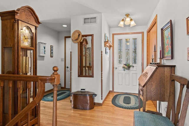 entryway with a notable chandelier, baseboards, visible vents, and light wood-style floors