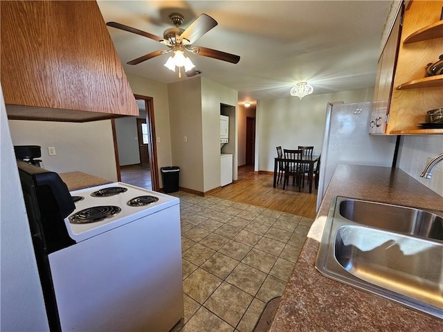 kitchen with open shelves, dark countertops, white electric range, light tile patterned flooring, and a sink