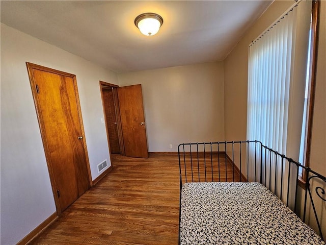 interior space with visible vents, baseboards, and wood finished floors