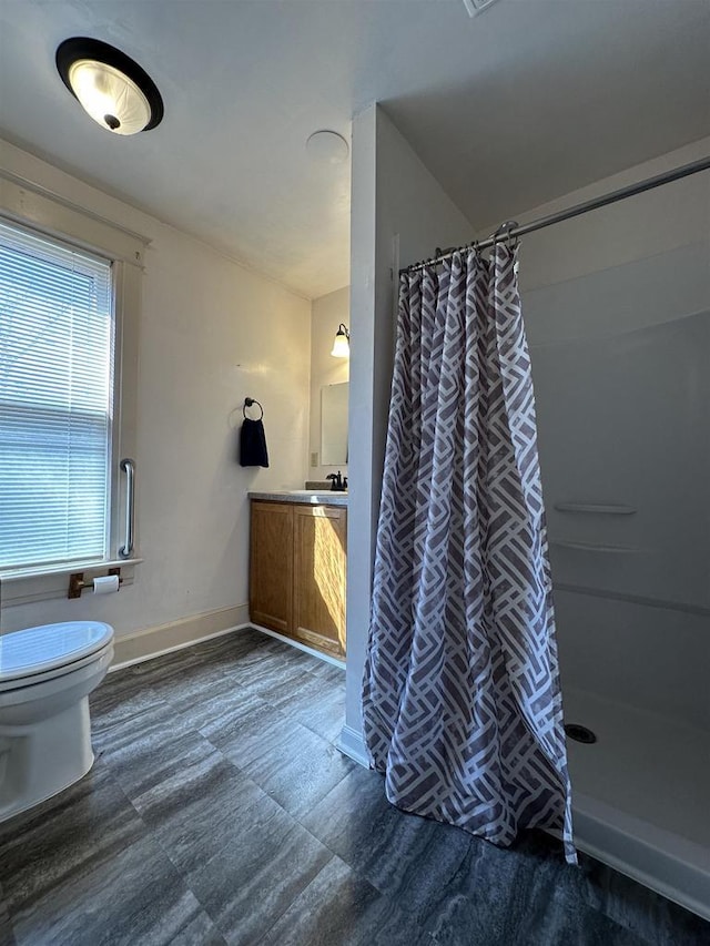 full bath with baseboards, a shower with shower curtain, vanity, and toilet