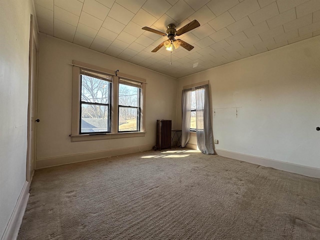 unfurnished room featuring carpet floors, radiator, baseboards, and a ceiling fan