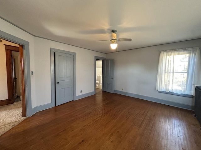 unfurnished bedroom with a ceiling fan, baseboards, and dark wood-type flooring