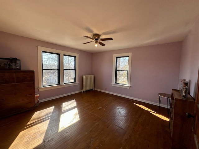 bedroom featuring ceiling fan, dark wood-style flooring, radiator heating unit, and baseboards