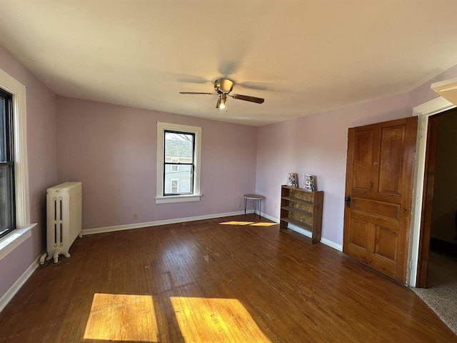 interior space with ceiling fan, radiator heating unit, wood finished floors, and baseboards