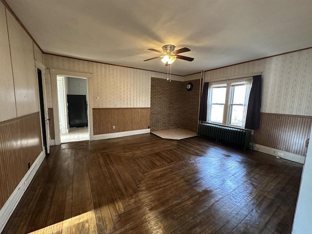 spare room featuring ornamental molding, radiator, wainscoting, and wallpapered walls