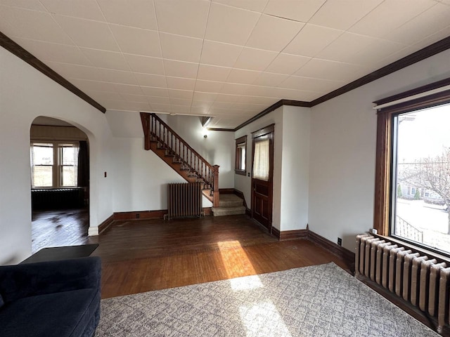 interior space featuring radiator, stairs, ornamental molding, and wood finished floors