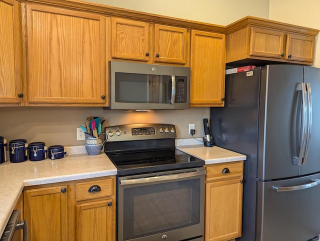 kitchen with light countertops, appliances with stainless steel finishes, and brown cabinetry