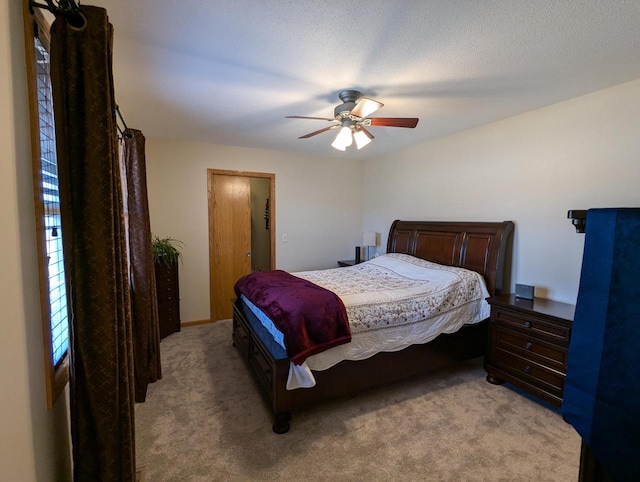 bedroom featuring a ceiling fan, light colored carpet, and a textured ceiling