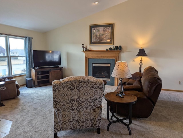 carpeted living room featuring lofted ceiling, a glass covered fireplace, and baseboards