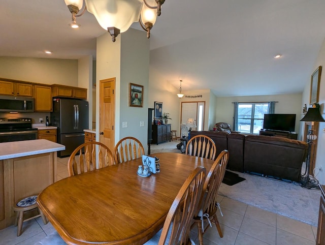 dining room featuring lofted ceiling and light tile patterned floors