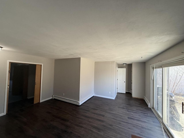 unfurnished room featuring dark wood-style floors, a baseboard heating unit, and baseboards