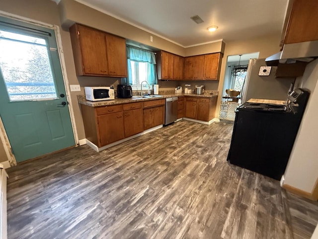 kitchen with white microwave, brown cabinetry, black range with gas stovetop, a sink, and dishwasher