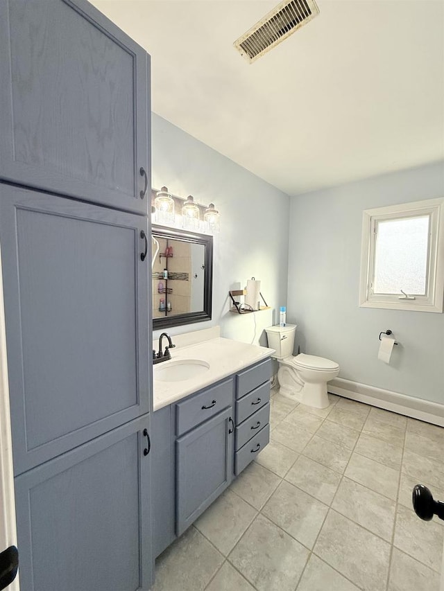 bathroom with toilet, vanity, baseboards, visible vents, and tile patterned floors