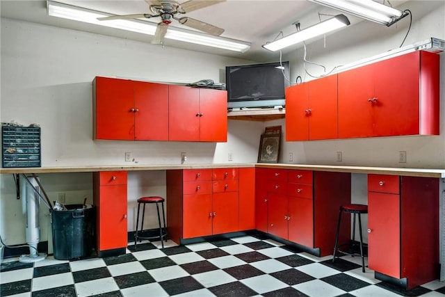 kitchen featuring red cabinetry, dark floors, light countertops, and a ceiling fan