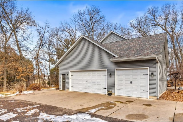 view of home's exterior with roof with shingles, driveway, and an attached garage