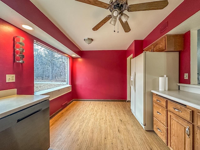 kitchen with light wood finished floors, white fridge with ice dispenser, brown cabinets, and light countertops