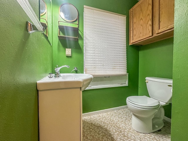 bathroom with baseboards, vanity, and toilet